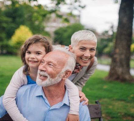 elder couple and grandchild smiling